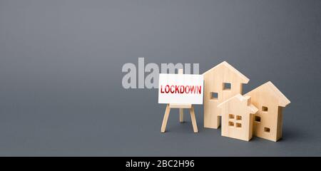 Figures of houses and an easel with the word Lockdown. Tough measures to stop new infections of coronavirus COVID-19 exponential growth. Self isolatio Stock Photo