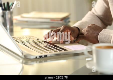 Close up of black man hands using touchpad on laptop on a desk at home Stock Photo