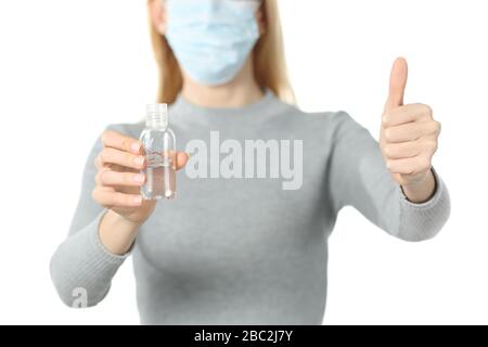 Close up of woman with protective mask and sanitizer rub doing thumb up isolated on white background Stock Photo