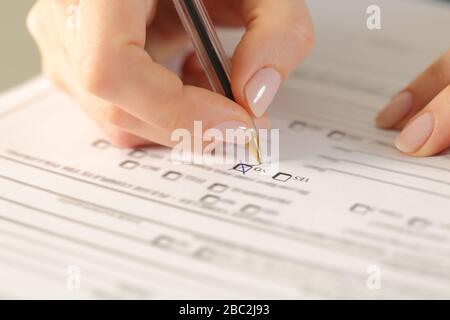 Close up of woman hands filling form crossing no checkbox Stock Photo