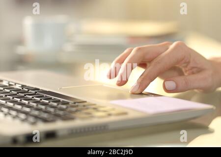 Close up of woman hand pressing touchpad button on laptop on a desk at home Stock Photo