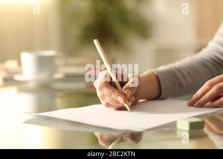 Close up of woman hands drawing with pencil on a paper sitting on a desk at home Stock Photo