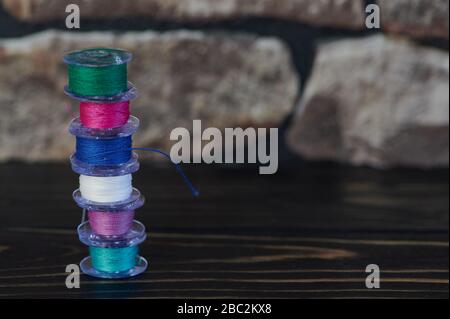 small tower of colored cotton thread on yarn bobbins Stock Photo
