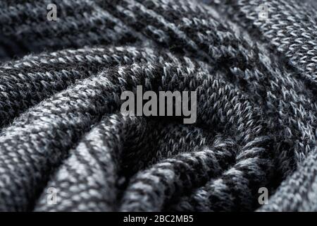 Closeup gray texture of woolen knitted fabric. Pattern of gray crumpled fabric. High-quality selective focus macro photography. Stock Photo