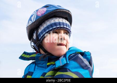Head of boy child kid with safety bike helmet looking away Stock Photo
