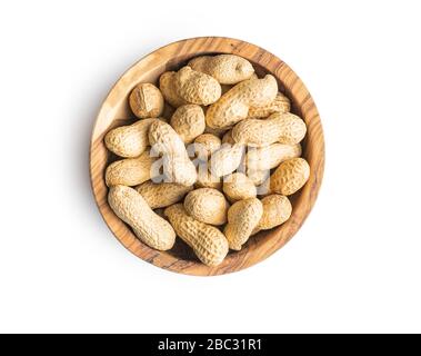 Tasty unpeeled peanuts in bowl isolated on white background. Stock Photo