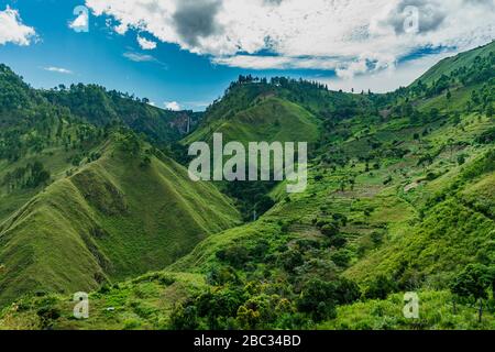 Vibrant lake toba slopes with one of the highest waterfalls in Indonesia Sipiso visible in distance Stock Photo