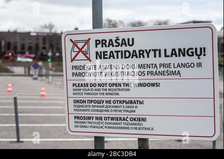 A sign displaying rules in Lithuanian, English, Russian and Polish, at a temporary, drive-through coronavirus / COVID-19 test centre in Vilnius Stock Photo