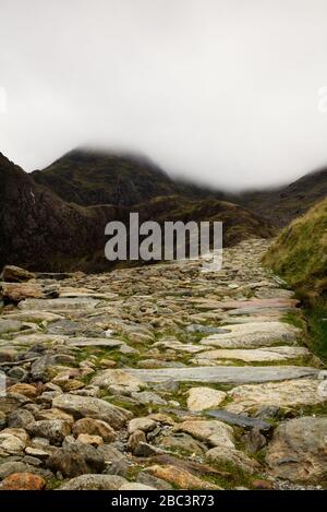 Mountain path leading up into the unknown beyond the clouds. Stock Photo