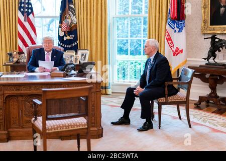 Washington, United States Of America. 01st Apr, 2020. Washington, United States of America. 01 April, 2020. U.S President Donald Trump and Vice President Mike Pence use the speaker phone to talk with military family members about the COVID-19, coronavirus pandemic from the Oval Office of the White House April 1, 2020 in Washington, DC. Credit: Tia Dufour/White House Photo/Alamy Live News Stock Photo