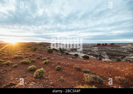 golden light of sunrise over camp at the edge of The Maze in Utah Stock Photo