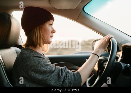 Inside view of woman driving in Big Sur at sunset Stock Photo