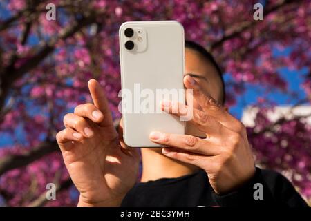 woman using cell phone outdoors in springtime Stock Photo