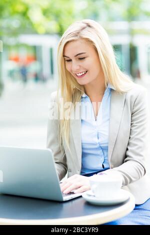 Businesswoman using laptop at cafe Stock Photo