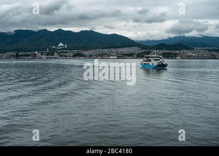 A ferry boat connecting Miyajima island (Itsukushima) with the mainland sailing in Hiroshima Bay, Japan Stock Photo