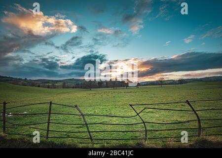 Dramatic sunset clouds over british countryside fields at early spring in Shropshire Stock Photo