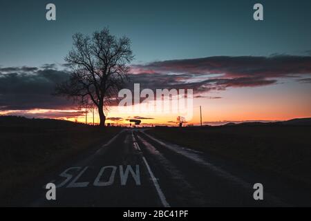 Dramatic colorful twilight clouds over empty apshalt road in United Kingdom Stock Photo
