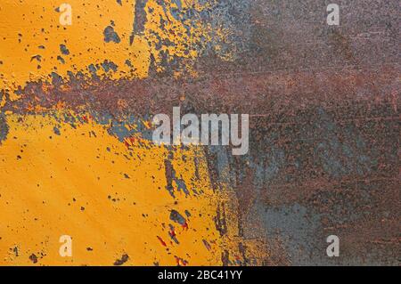 partly painted yellow old rusty scratched iron metal background Stock Photo