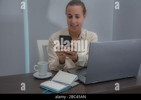 Female administrative working in the office and answering the phone Stock Photo