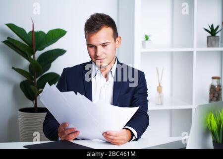 Solid businessman in a jacket works with documents in office of the company. Stock Photo