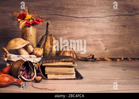Autumn Thanksgiving arrangement with wooden mushrooms. Fall leaves, apples, peppers and chestnuts. Autumn still life arrangement indoors, old antique Stock Photo