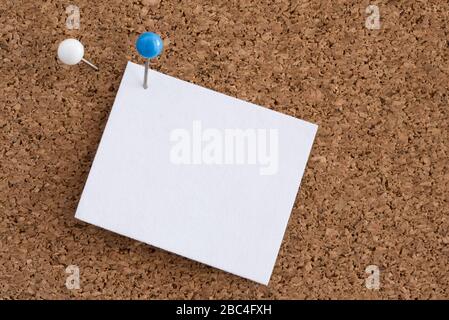 Blue Pin Holding a Blank Paper to Corkboard Stock Photo