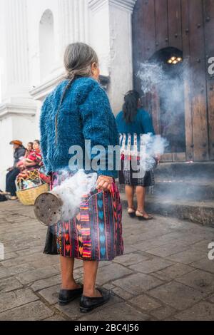 Mayan women swing thuribles outside the St. Thomas church in Chichicastenango, Guatemala. Stock Photo