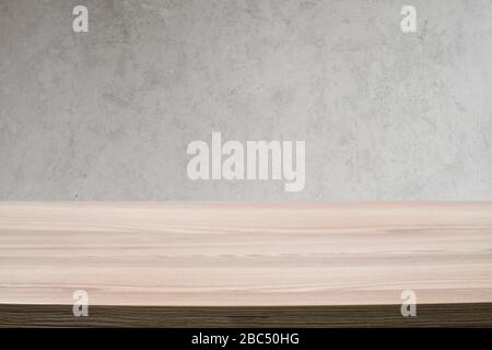 Empty light wooden table against a modern grunge concrete wall. Plenty of space for copy Stock Photo