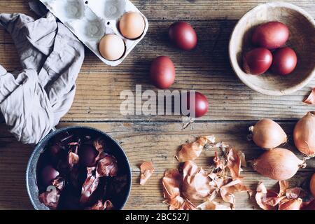 Dyed Easter eggs painted with natural dye onion on rustic wooden background. Process of dyeing eggs with natural paints for Easter. Natural ecological Stock Photo