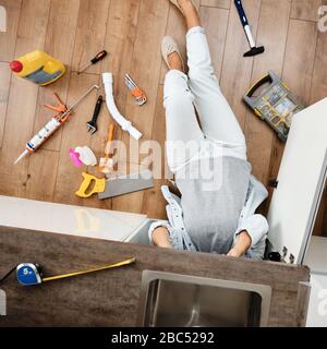 Woman fixing kitchen sink Stock Photo
