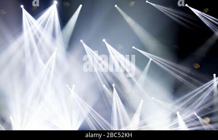 Stage lights on concert. Lighting equipment with white colored beams. Stock Photo