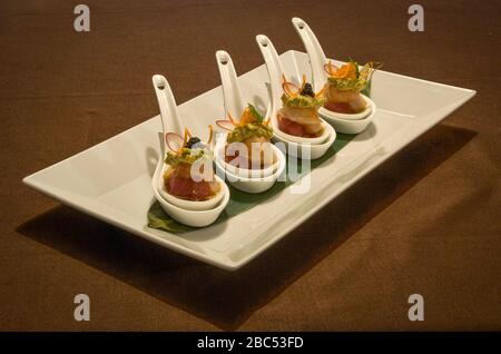 Delicious finger fusion food in white spoons - shrimp, eggplant and tomatoes ingredients in fusion and cuisine design Stock Photo