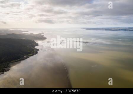 Aerial view on the Kaipara Harbour mudflats close to Ruawai, New Zealand. This is a morning scene on a sunny day with a few clouds on the sky that ref Stock Photo