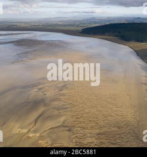 Aerial view on the Kaipara Harbour mudflats close to Ruawai, New Zealand. This is a morning scene on a sunny day with a few clouds on the sky that ref Stock Photo