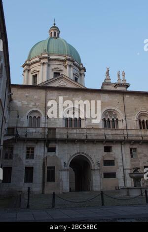 Brescia, Italy - August 1 2018: the view of the inner yard of medieval palace Palazzo del Broletto with dome of the New Cathedral on background on Aug Stock Photo