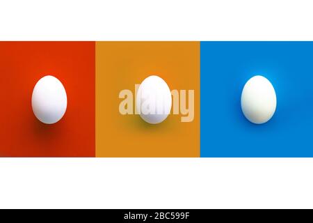 Collage of red, orange and blue rectangles with three white chicken eggs. white background. Copy space. Top view Stock Photo