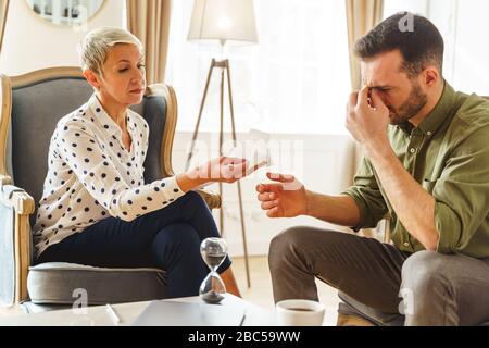 Frustrated man sitting in his psychoanalysts office Stock Photo