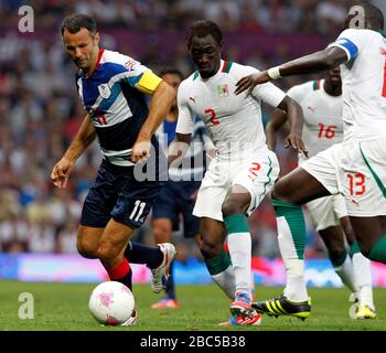 Great Britain's Ryan Giggs battles for possesion with Senegal's Saliou Ciss during the Great Britain v Senegal, Mens Football, First Round, Group A match at Old Trafford, Manchester. Stock Photo