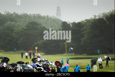 England's Lee Westwood tees off from the 18th as players walk down the 2nd fairway behind Stock Photo