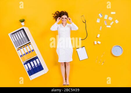 Top above high angle view full length photo of qualified woman doc flat lay pills drugs clipboard syringe clock touch specs in medical office isolated Stock Photo