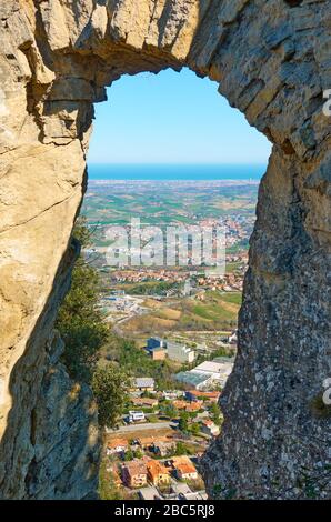 View through arch of The Pass of the Witches in San Marino to  Borgo Maggiore valley of Emilia-Romagna in Italy Stock Photo