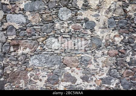 Uneven real stone wall background or texture. Stock Photo