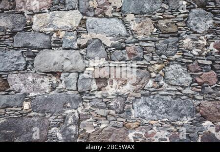 Uneven real stone wall background or texture. Stock Photo