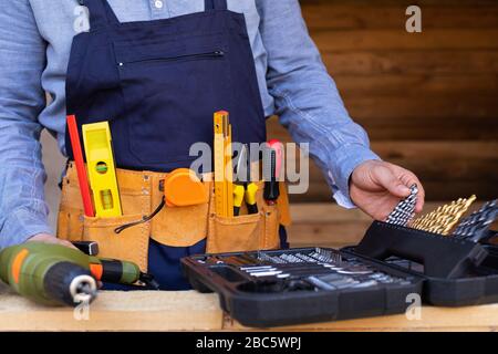 Close up picture of carpenters tool belt and work instruments on wooden background Stock Photo