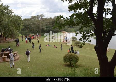 LILONGWE, MALAWI, AFRICA - APRIL 1, 2018: African teenagers are having party, dancing and rest on the grass near Kamuzu Dam II. Stock Photo