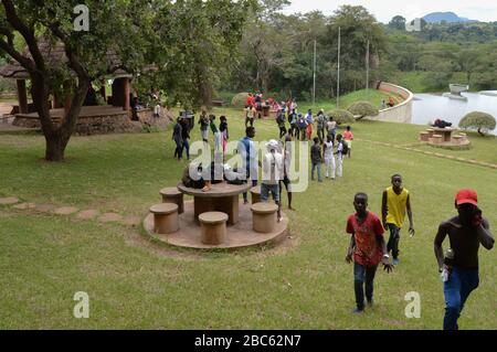 LILONGWE, MALAWI, AFRICA - APRIL 1, 2018: Three boys are going up from the the grass field of Kamuzu dam II, where african teenagers are having party Stock Photo