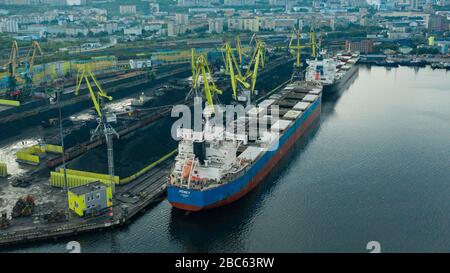 Murmansk, Russia - August 18, 2019: Vessels at the mooring of the coal terminal of the port of Murmansk. Shooting from above drone. Stock Photo