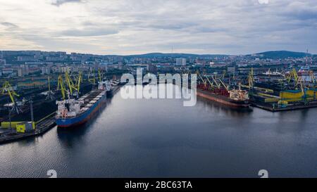 Murmansk, Russia - August 18, 2019: Vessels at the mooring of the coal terminal of the port of Murmansk. Shooting from above drone. Stock Photo