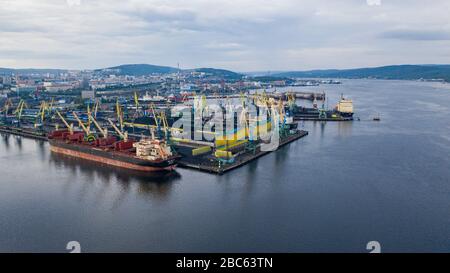 Murmansk, Russia - August 18, 2019: Vessels at the mooring of the coal terminal of the port of Murmansk. Shooting from above drone. Stock Photo