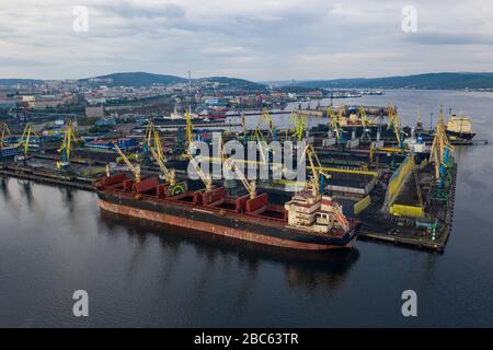 Murmansk, Russia - August 18, 2019: Vessels at the mooring of the coal terminal of the port of Murmansk. Shooting from above drone. Stock Photo